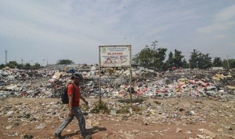 Pejalan kaki melintasi Tempat Pembuangan Sampah (TPS) ilegal di Bintara Jaya Bekasi, Jawa Barat,Rabu (7/8/2019). 