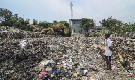 Warga mengamati alat berat Excavator beraktifitas di Tempat Pembuangan Sampah (TPS) Ilegal di Kampung Kedaung, Jakasampurna, Bekasi, Jawa Barat, Rabu (7/8/2019). Terlibat Pembuangan Sampah Ilegal Bisa Dipenjara 15 Tahun