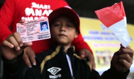 Seorang anak menunjukkan Kartu Identitas Anak (KIA) yang baru diterimanya di Banda Aceh, Aceh, Kamis (8/8/2019).