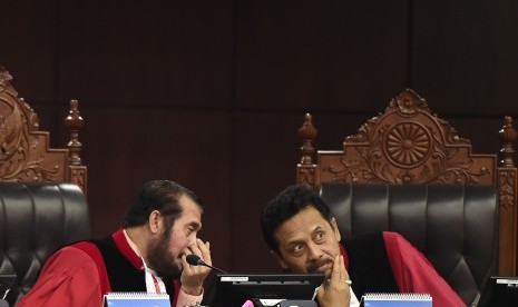 Ketua Mahkamah Konstitusi (MK) sekaligus pimpinan Majelis Hakim MK Anwar Usman (kiri) berdiskusi dengan Hakim MK I Dewa Gede Palguna di sela sidang putusan akhir untuk perkara sengketa hasil Pemilu Legislatif 2019 di Ruang Sidang Pleno Gedung MK, Jakarta, Jumat (9/8/2019). 