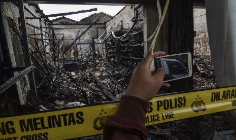 Jurnalis mengambil gambar sisa kebakaran ruko di daerah Cipayung,Jakarta Timur, Jumat (9/8/2019). 