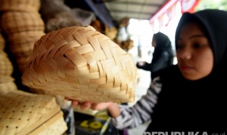 Seorang calon pembeli mencermati besek bambu yang dijual di sebuah kios di Jalan Jatinegara Barat, Jakarta Timur, Sabtu (10/9/2019).