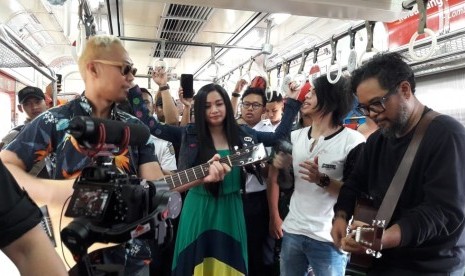 Band Cokelat tampil di salah satu gerbong KRL tujuan Bogor - Jakarta Kota, Kamis (15/8).