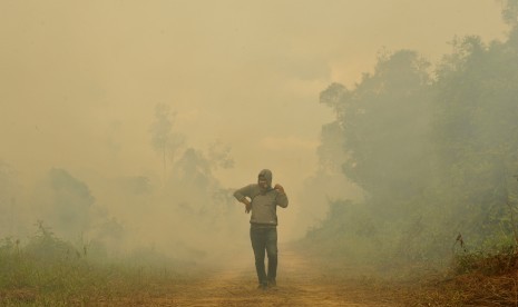 Warga berada di sekitar lahan gambut yang terbakar di Kumpeh Ulu, Muarojambi, Jambi, Kamis (15/8/2019).