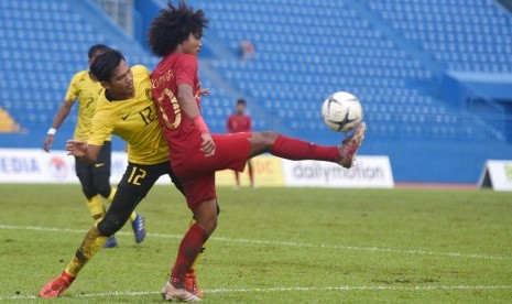 Pesepak bola Indonesia Bagus Kahfi (kanan) berebut bola dengan pesepak bola Malaysia Muhammad Aidil Azuan (kiri) saat bertanding pada semifinal Piala AFF U-18 di Stadion Go Dau di Provinsi Binh Duong, Vietnam, Sabtu (17/8/2019).