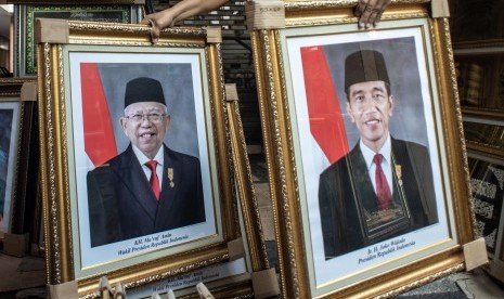 Pedagang merapikan poster Presiden Joko Widodo dan Wakil Presiden terpilih Ma'ruf Amin yang dijualnya di kawasan Sawah Besar, Jakarta, Rabu (21/8/2019).