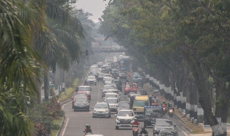 Pengendara kendaraan bermotor melintas di Jalan Sudirman ketika kabut asap tipis dampak dari kebakaran hutan dan lahan masih menyelimuti Kota Pekanbaru, Riau, Kamis (22/8/2019).