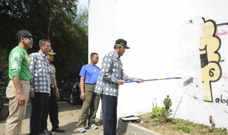 Bupati Sleman, Sri Purnomo, melakukan pembersihan terhadap  bangunan Cagar Budaya Jembatan Rel Pangukan yang menjadi korban aksi  vandalisme, Jumat (23/8).