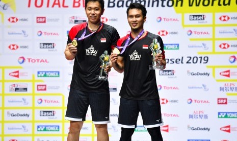 Ganda putra Indonesia Hendra Setiawan (kiri) dan Mohammad Ahsan menunjukan medali emas usai mengalahkan ganda putra Jepang Takuro Hoki dan Yugo Kobayashi pada babak final Kejuaraan Dunia Bulu Tangkis 2019 di St. Jakobshalle, Basel, Swiss, Minggu (25/8/2019).