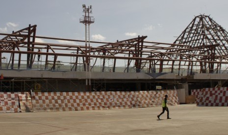 Seorang pria berjalan di depan terminal Bandara El Tari Kupang yang sedang dikerjakan oleh sejumlah pekerja. 