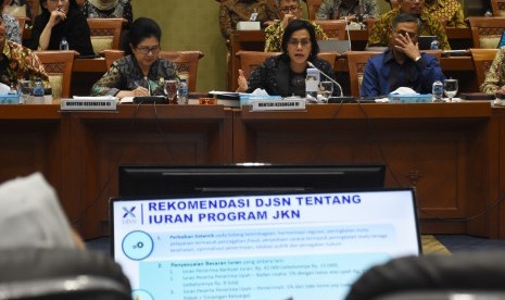 Menteri Keuangan Sri Mulyani Indrawati (tengah) dan Menteri Kesehatan Nila F. Moeloek (kiri) menyampaikan paparannya saat mengikuti rapat kerja gabungan dengan dengan Komisi IX dan Komisi XI DPR di Kompleks Parlemen Senayan, Jakarta, Selasa (27/8/2019). 