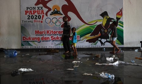 Warga melintas di depan baliho sosialisasi PON XX Tahun 2020 di Kantor Gubernur Papua, Jayapura, Papua, Sabtu (31/8/2019).