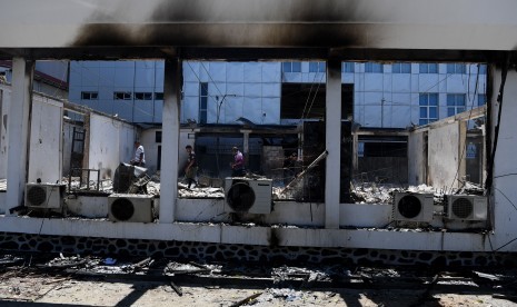 Karyawan memeriksa kondisi bangunan Kantor KPU Papua yang hangus terbakar di Jayapura, Papua, Sabtu (31/8/2019).