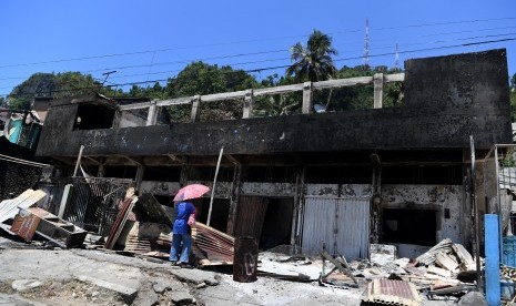 Warga mengamati rumah warga yang terbakar di Jayapura, Papua, Sabtu (31/8/2019). 