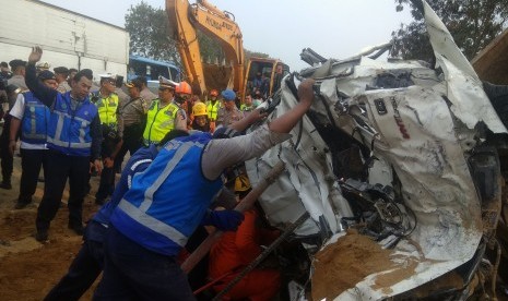 Petugas mengevakuasi salah satu kendaraan yang terlibat pada kecelakaan beruntun di Tol Cipularang KM 92 Purwakarta, Jawa Barat, Senin (2/9/2019).