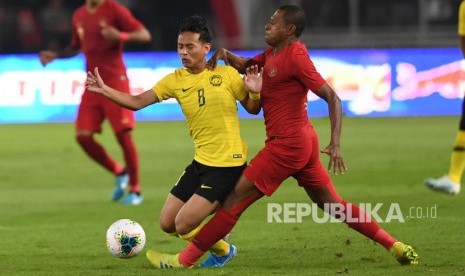 Pemain Timnas Indonesia Yustinus Paew (kanan) berebut bola dengan pemain Timnas Malaysia Muhamad Nor Azam saat laga perdana Grup G Kualifikasi Piala Dunia 2022 zona Asia di Stadion Utama Gelora Bung Karno, Senayan, Jakarta, Kamis (5/9/2019).