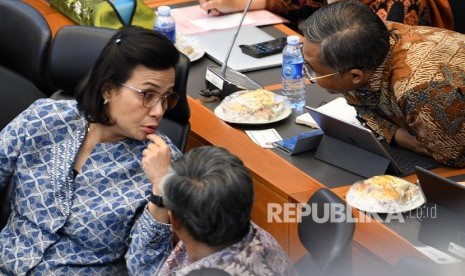 Menteri Keuangan Sri Mulyani Indrawati (kiri) berdiskusi dengan stafnya di sela rapat kerja dengan Badan Anggaran (Banggar) DPR RI di kompleks Parlemen, Jakarta, Jumat (6/9/2019).