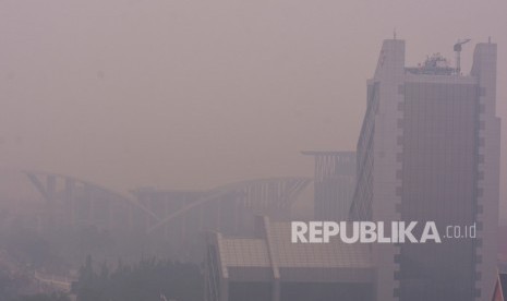 Gedung Perpustakaan Daerah Soeman HS (kiri) dan Menara Bank Riau-Kepri (kanan) tampak samar-samar ketika kabut asap kebakaran hutan dan lahan (Karhutla) menyelimuti Kota Pekanbaru, Riau, Selasa (10/9/2019). 