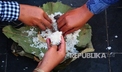 Warga makan nasi jangkrik saat puncak acara Bukak Luwur Sunan Kudus di kawasan Masjid Menara Kudus, Jawa Tengah, Selasa (10/9/2019).