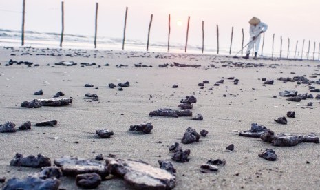 Petugas mengumpulkan ceceran tumpahan minyak mentah di Pantai Sedari, Cibuaya, Karawang, Jawa Barat, Selasa (10/9/2019). 