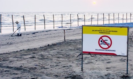 Petugas mengumpulkan ceceran tumpahan minyak mentah di Pantai Sedari, Cibuaya, Karawang, Jawa Barat, Selasa (10/9/2019). 