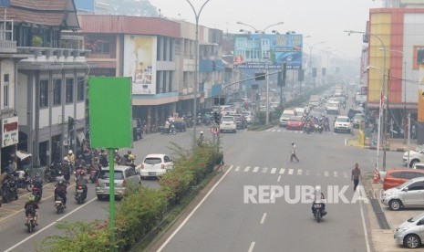 Sejumlah pengendara melintasi jalan yang diselimuti kabut asap di Pontianak, Kalimantan Barat, Selasa (10/9/2019).