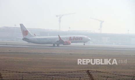 Pesawat komersial mendarat di Bandara Syamsudin Noor yang di selimuti kabut asap di Banjarbaru, Kalimantan Selatan, Rabu (11/9/2019).