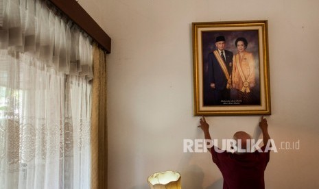 Asisten rumah tangga merapikan foto almarhum Presiden ke-3 Republik Indonesia BJ Habibie dan almarhumah Ibu Hasri Ainun Habibie di rumah milik ibunda RA Habibie di Bandung, Jawa Barat, Kamis (12/9/2019).