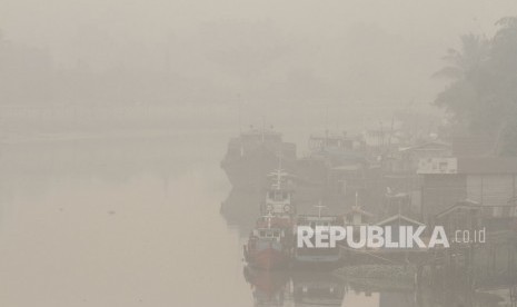 Sejumlah kapal terparkir di pelabuhan rakyat sungai Siak ketika kabut asap pekat dampak dari kebakaran hutan dan lahan menyelimuti Kota Pekanbaru, Riau, Jumat (13/9/2019).