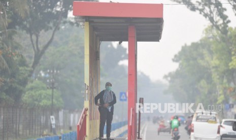 Ilustrasi. Warga menggunakan masker saat beraktivitas di Padang yang diselimuti kabut asap, Sumatera Barat.