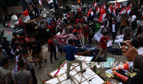 Massa dari Aliansi Mahasiswa dan Pemuda Relawan Cinta NKRI merusak karangan bunga saat unjuk rasa yang berakhir ricuh di kantor KPK, Jakarta, Jumat (13/9/2019).