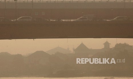 Sebuah kapal motor melitasi Sungai Musi yang diselimuti kabut asap di Palembang, Sumatera Selatan, Jumat (13/9/2019).