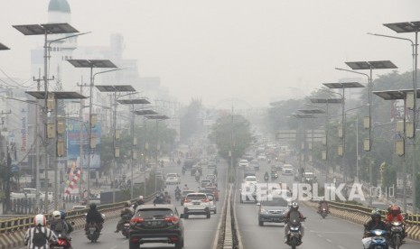 Sejumlah kendaraan bermotor melintas di Fly Over jalan Ahmad Yani yang terpapar kabut asap di Banjarmasin, Kalimantan Selatan, Ahad (15/9/2019)