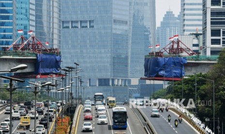 Pengendara melintas di bawah pembangunan proyek Light Rail Transit (LRT) Jabodebek di kawasan Kuningan, Jakarta, Senin (16/9/2019).