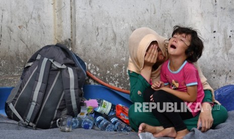 Seorang anak pencari suaka menangis di pangkuan ibunya di trotoar dekat kantor Komisioner Tinggi PBB untuk Pengungsi (UNHCR), Jalan Kebon Sirih, Jakarta Pusat, Selasa (17/9/2019). 