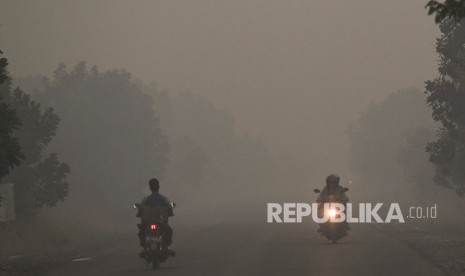 Kendaraan melintas di jalanan yang diselimuti asap di daerah Panarung, Palangka Raya, Kalimantan Tengah, Selasa (17/9/2019). 