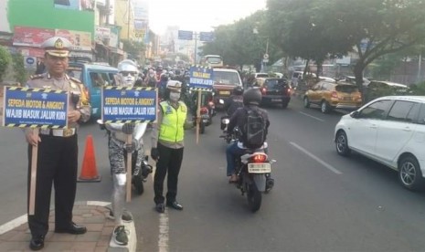 Satuan Lalu Lintas (Satlantas) Polresta Depok melakukan sosialisasi penggunaan jalur lambat untuk kendaraan motor dan angkutan kota (angkot) di Jalan Margonda, Kota Depok, Rabu (18/9). 