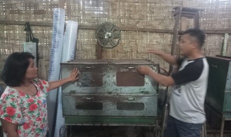 Rosmania Rajaguguk (putih kembang-kembang), dan suaminya Rudi Pardosi (putih hitam) menjelaskan usaha kue kacangnya yang dikembangkan dengan pinjaman syariah tanpa agunan BTPN Syariah, pada Business Coach BTPN Syariah, Fauzahln Ridha (hitam). Medan, Sumatera Utara. 