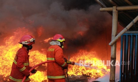 Petugas pemadam kebakaran mencoba memadamkan api (ilustrasi). Total 60 kios di Pasar Cinde Palembang hangus dilalap si jago merah.