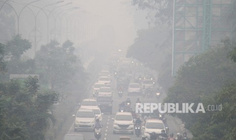 Sejumlah pengendara melintasi jalan yang diselimuti kabut asap sangat pekat di Pontianak, Kalimantan Barat, Jumat (20/9/2019).