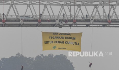 Aktivis lingkungan Greenpeace Indonesia dan Save Our Borneo melakukan aksi pembentangan spanduk raksasa di bawah Jembatan Kahayan, Palangka Raya, Kalimantan Tengah, Ahad (22/9/2019).