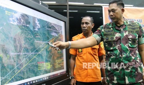 Komandan Pangkalan TNI AU Yohanes Kapiyau Timika Letkol Penerbang Sugeng Sugiharto (kanan) menunjukkan lokasi penemuan serpihan yang diduga pesawat Twin Otter DHC6-400 bernomor registrasi PK CDC milik PT Carpediem yang hilang kontak di Papua saat memberikan keterangan di Mimika, Papua, Ahad (22/9/2019).