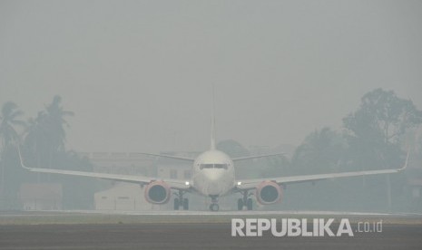 Sebuah pesawat udara bersiap lepas landas di Bandara Sultan Thaha yang diselimuti kabut asap karhutla, Jambi, Senin (23/9/2019). 