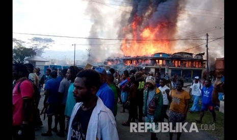  Massa berkumpul dekat toko-toko yang terbakar di Wamena, Provinsi Papua,, Senin (23/9). 