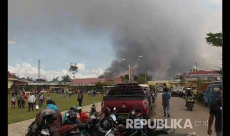   Asap hitam membumbung akibat gedung yang terbakar  saat kerusuhan di Wamena, Provinsi Papua,, Senin (23/9). 