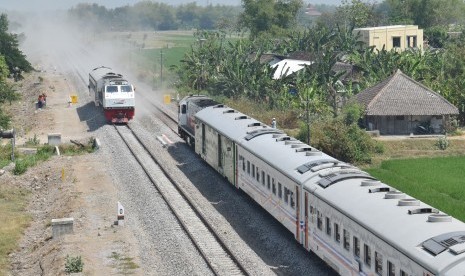 Rangkaian kereta uji beban (kiri) melintasi jalur baru di samping KA 155 Singasari relasi Blitar-Pasar Senen di jalur ganda Kereta Api (KA) di Madiun, Jawa Timur, Selasa (24/9/2019).