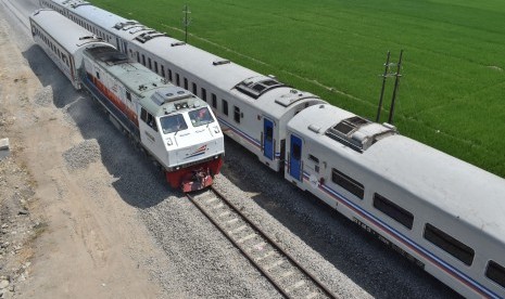 Rangkaian kereta uji beban (kiri) melintasi jalur baru di samping KA 155 Singasari relasi Blitar-Pasar Senen di jalur ganda Kereta Api (KA) di Madiun, Jawa Timur, Selasa (24/9/2019).