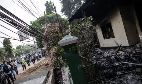 Sejumlah warga berjalan di depan kantor Polisi Subsektor Palmerah yang hangus terbakar pascaunjuk rasa mahasiswa di Jalan Gelora, Senayan, Jakarta, Rabu (25/9/2019).