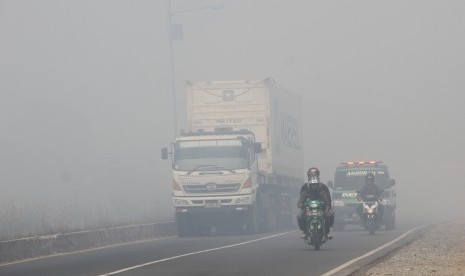 Sejumlah kendaraan bermotor melintas di jalan lingkar selatan yang diselimuti kabut asap pekat di Banjarbaru, Kalimantan Selatan, Rabu (25/9/2019). 