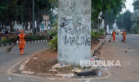 Petugas PPSU membersihkan sampah (ilustrasi). Dinas Lingkungan Hidup DKI Jakarta menyebutkan sekitar 2,1 ton sampah dibersihkan dari lokasi unjuk rasa memprotes Undang-Undang Cipta Kerja pada Selasa.